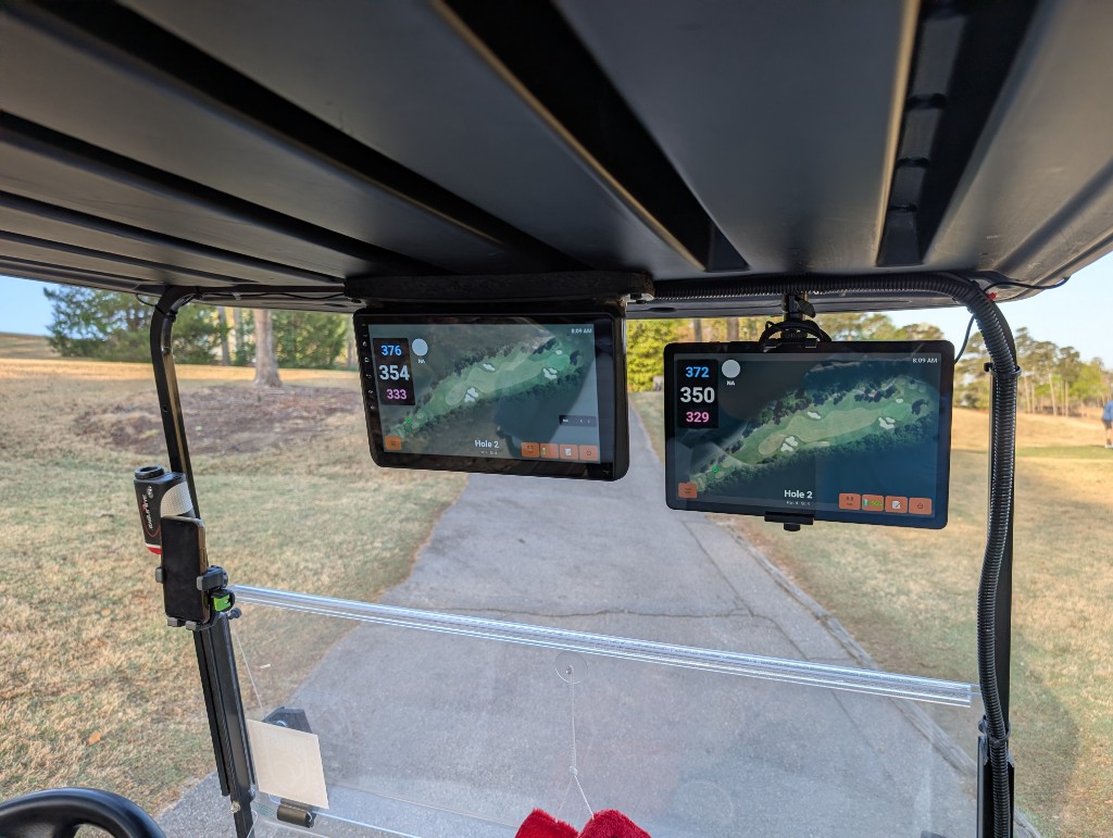 Two tablets running Aimy mounted in a golf cart on the course, showing hole map with distances